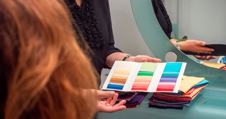 Mani di Federica Grimaldi che sfogliano i drappi colorati per l'analisi del colore